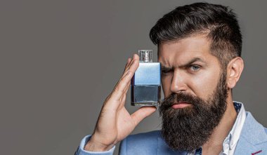 Erkek sakallı, elinde parfüm şişesi tutuyor. Parfüm ya da parfüm şişesi ve parfüm, kozmetik, parfüm şişesi, kolonya tutan erkek..