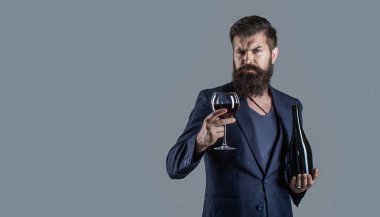 Elinde bir kadeh kırmızı şarap. Sommelier, bir bardak şarap, şarap imalatçısı, erkek şarap üreticisi. Sakallı adam, sakallı, şarap içen şarap garsonu..