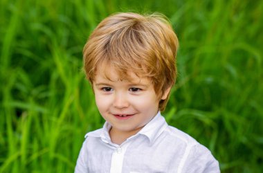 Çocuk dışarıda. Mutlu çocuk. Yeşil çimlerin üzerinde izole edilmiş komik bir erkek bebek. Gülümseyen çocuk. Küçük bir çocuğun portresi. Doğa parkında çocuk portresi..