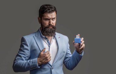 Erkek parfümü, parfüm. Erkeksi parfüm. Erkek parfümü, parfüm, kozmetik. Sakallı adam elinde bir şişe parfüm tutuyor. Moda parfüm şişesi..