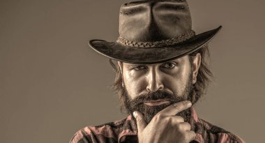 Deri kovboy şapkası. Kovboy şapkasını ayarlayan yakışıklı genç adam. Şapkalı kovboylar. Amerikan kovboyu.
