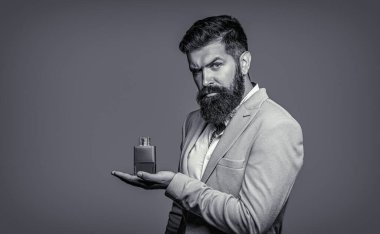 Parfüm, şişe, parfüm, kozmetik. Erkek parfümü, siyah beyaz takım elbiseli sakallı adam.
