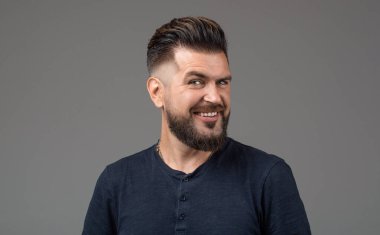 Sakallı adam, şık saç stili. Genç sakallı adam, şık saç stili, sakallı. Mükemmel sakal. Tarz sahibi bir adamın portresi. Tek başına gülümseyen erkek portresi.