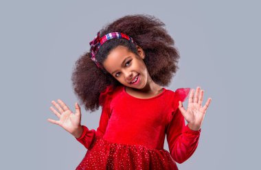 Gülümseyen tatlı küçük kız. Gülümse küçük Afrikalı Amerikalı kız. Afrikalı kız gülüşü ve kıvırcık saçlar. Gülen afro kız portresi. Gülümseyerek, gülerek, portreyle kameraya bakan mutlu genç kız..
