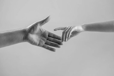 Çocuk ve baba elleri gride izole edilmiş. El konseptine yardım etmek, destek olmak. Siyah ve beyaz.