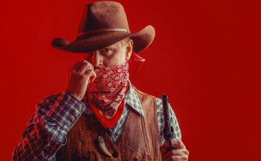 Şapkalı kovboy portresi. Kovboy şapkalı, silahlı, maço bir adam. Batı, silahlar..