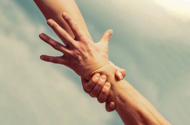 Yardım, eller, destek. Mavi gökyüzü arkaplanının elleri. Erkek eli..