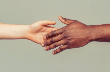 Kadın ve erkek el ele tutuşuyor. Kadın ve Afrikalı kadın eli. Bir başkasına yardım eli uzatmak..
