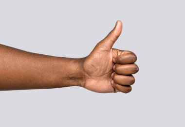 Afrika erkek eli baş parmağını gösteriyor. Afro-amerikan elleri. Jest gibi. Yakından çekilen el başparmaklarını gösteriyor. Erkek elleri baş parmağını kaldırıyor. Destek desteği.