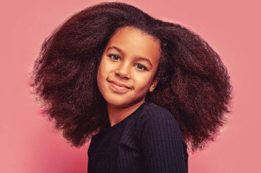 Gülümseyen Afrikalı Amerikalı kız, keyif alıyor, mutluluk ve neşe gösteriyor, neşeli, kaygısız, boş zaman, tatil. Afro saçlı, gülümseyen güzel Afrikalı Amerikalı kız çocuğu..