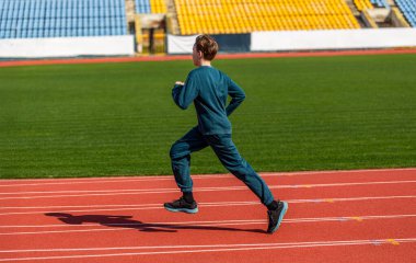 Atletizm yapan bir çocuk. Yarışta genç bir sporcu. Çocuklar için sağlıklı bir açık hava sporu. Çocuklar koşar. Genç bir çocuk stadyumdaki koşu pistinde koşuyor. Stadyumda koşan çocuk.