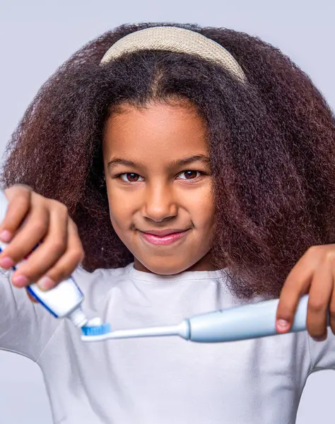 Sağlıklı dişler, diş macunu. Küçük tatlı Afrikalı Amerikalı kız dişlerini fırçalıyor..