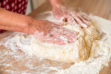 Yaşlı kadın elleri - buğday ekmeği için hamur işliyor. Hazırlık hamurları. Hazırlık hamuru kadın eli gibidir. Pastanede erkeklerin elinden para kazanıyordum. Yemek konsepti. Eller havaya..