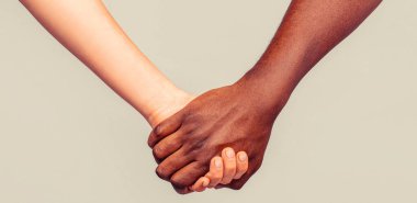 Çok ırklı bir çift el ele tutuşuyor. Siyah adam ve kadın. İlişki ve yakınlık. Siyah beyaz el aşk ortaklığı.