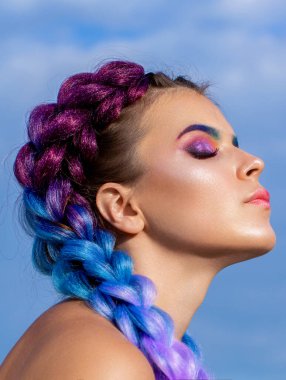 Renkli saç örgüleri. Saç örgüsü, saç örgüsü. Saçına örülmüş renkli Kanekalon kızı. İki kalın saç örgüsü..