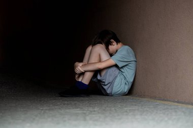 Sokakta yalnız başına oturan üzgün çocuk depresyondan muzdarip. Yüzünü örten korkmuş, küçük bir çocuk. Çocuk bağırıyor, elleriyle yüzünü kapatıyor, zorbalık yapıyor. Yalnız bir çocuk tünelde oturuyor..