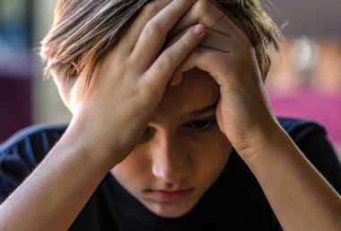 Çocuk evde yalnız başına üzgün hissediyor. Üzgün çocuk, stres ve depresyon. Zorbalık, depresyon stresi ya da hüsran gibi konularda kafası çalışan sorunlu çocuklar..