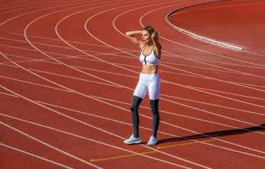 Stadyumda antrenman yapmak, antrenman yapmak ya da nefes almak için yorgun bir kadın. Stadyumdaki yorgun kız. Spor, yarış ve bir atlet koşucusu, fitness, koşu ya da pistte egzersiz.