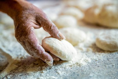 Evde hamurla çalışma süreci. Pişirmek için kurabiye hamuru, çiğ hamur parçaları. Hamur hazırlayan kadın şef mutfakta cheesecake yapıyor, yakın plan..