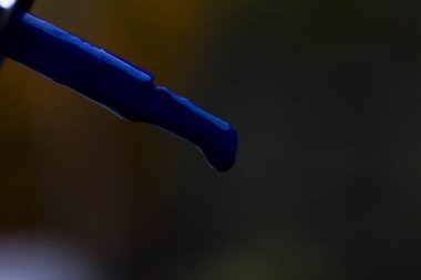 Yakından bir fırça üzerinde bir damla mavi laquer