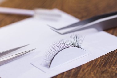 Kirpik uzatma seti ve masadaki testçiye kirpik uzatma eğitimi.