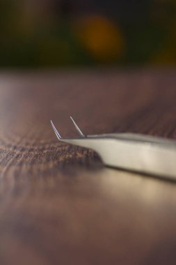 Gümüş kirpik uzatma cımbızı yakın plan ahşap arka plan