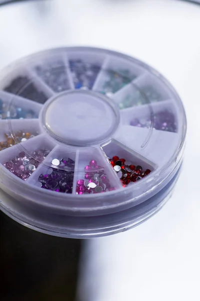 Box with rhinestones for manicure and makeup on a mirror background