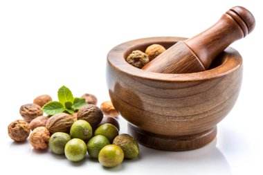 Triphala, beyaz arka planda izole edilmiş harç ve tokmakla ayurvedik meyve kombinasyonu