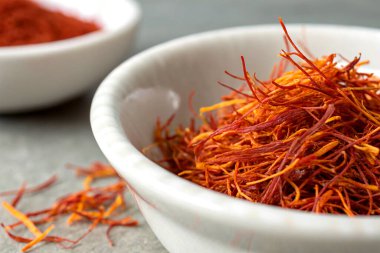 A close-up of saffron strands in a white porcelain bowl clipart