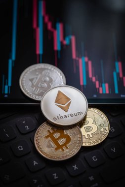 Stack or heap of gold various cryptocurrency near a monitor with candle stick graph chart and digital calculator. Bitcoin, Ethereum, Cardano, Litecoin.