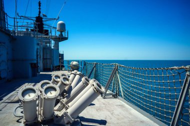 Chaff launcher is seen on the deck of a military ship sailing on the sea.