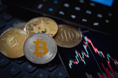 Altın Bitcoin ve Ethereum kripto para birimleri mum çubuğu grafik şeması, dizüstü bilgisayar klavyesi ve dijital arkaplan.