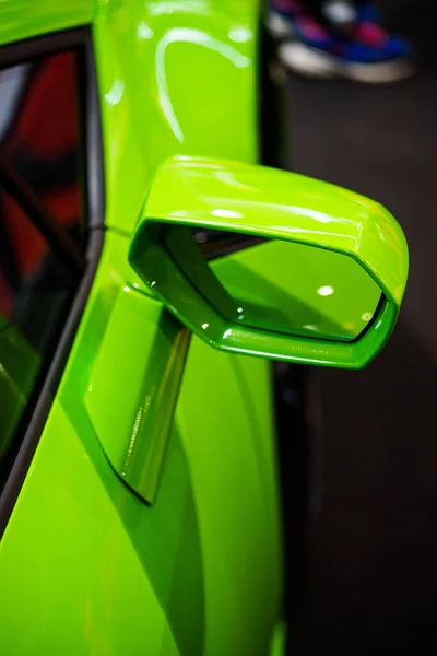 Image of a green sport car side rear view mirror.