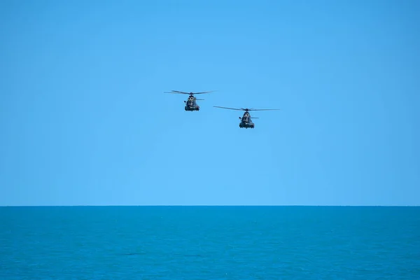 Kolorowy Obraz Dwóch Wojskowych Helikopterów Latających Nad Morzem — Zdjęcie stockowe