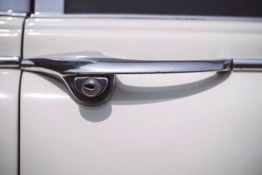 Beyaz bir arabanın klasik kapı kolunu yakından çek..