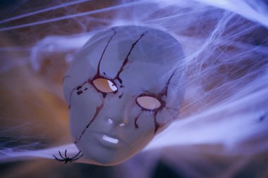 Beyaz bir maskenin renkli görüntüsü, kanla boyanmış, örümcekler ve örümcekler, cadılar bayramı süsü olarak..