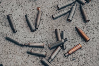 Machine gun empty bullet cartridges lay on the ground after being fired.