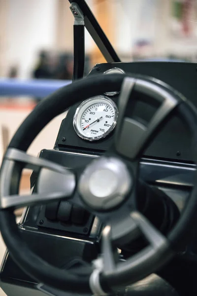 Close up shot of the steering wheel and dashboard of a motor boat.