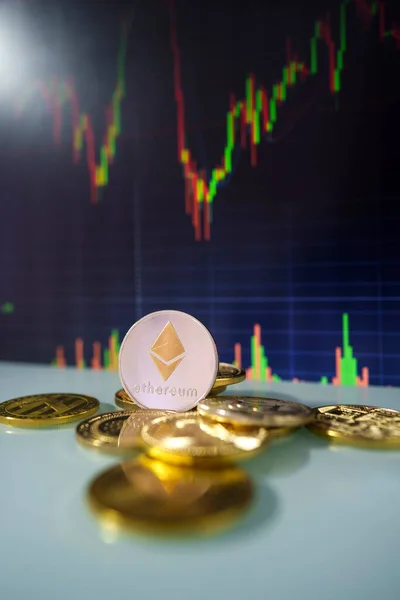 Stack or heap of gold Ethereum cryptocurrency with candle stick graph chart and digital background.