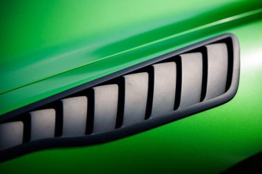 Aerodynamic green exotic supercar detail of gloss carbon part with beautiful shapes.