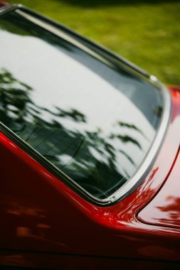 Renkli kırmızı bir arabanın arka camının yakın plan görüntüsü.