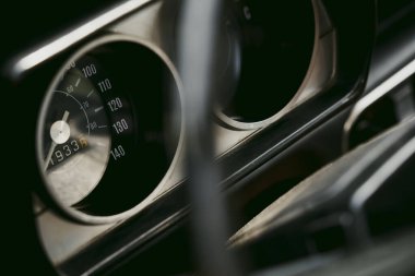 Close up shot of a speedometer gauge on an old vintage car.