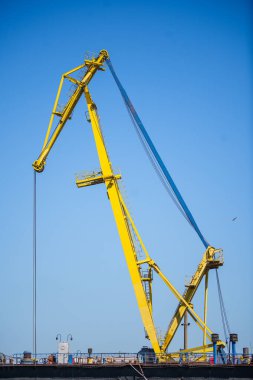 Ticari bir portta vinçlerle birlikte bir konteynır terminalinin renkli görüntüsü.