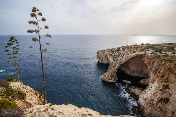 View of the natural stone arch and sea caves at Blue Grotto, Malta.