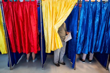Seçimler sırasında oy kullanma kabinlerinde ve perdeleri olan insanlar.