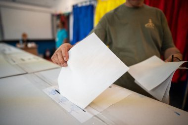 Seçimler sırasında sandıkta oy kullanırken bir kişi sandığa oy veriyor.
