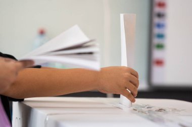 Seçimler sırasında sandıkta oy kullanırken bir kişi sandığa oy veriyor.