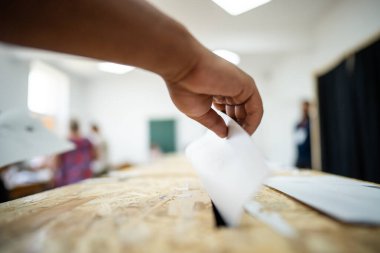 Seçimler sırasında sandıkta oy kullanırken bir kişi sandığa oy veriyor.