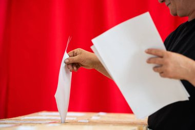 Seçimler sırasında sandıkta oy kullanırken bir kişi sandığa oy veriyor.