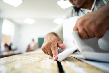 Seçimler sırasında sandıkta oy kullanırken bir kişi sandığa oy veriyor.